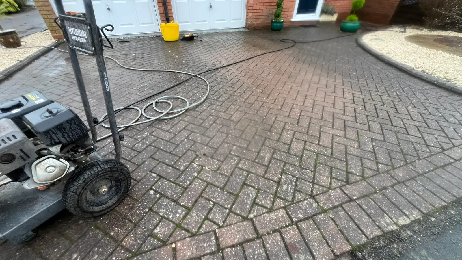 Pressure washer set up on a driveway